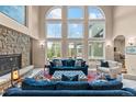 A cozy living room showcases a stone fireplace and expansive windows with natural light at 11406 Conifer Ridge Dr, Conifer, CO 80433