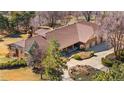 Aerial view of the single Gathering home with large lot, circle driveway, and mature trees at 6980 Oak St, Arvada, CO 80004