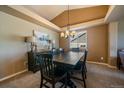 Formal dining room with dark wood table, modern chandelier, and lots of natural light at 1758 Parkdale N Cir, Erie, CO 80516