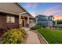 Inviting covered front porch with detailed columns and well-manicured landscaping at 1758 Parkdale N Cir, Erie, CO 80516