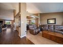 Open-concept living room with neutral tones, plush seating, and hardwood floors at 1758 Parkdale N Cir, Erie, CO 80516