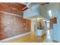 Open living area with exposed brick wall and hardwood floors at 3233 Osage St # 2A, Denver, CO 80211