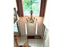 Bright foyer with large chandelier, tile floor, and a large window with lots of light and a view of nature at 15292 E Hialeah Pl, Aurora, CO 80015