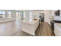 Stylish open kitchen with an island, modern appliances, and quartz countertops overlooking a dining area at 968 Congress Pl, Elizabeth, CO 80107