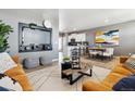 Inviting open-concept living space with a sleek entertainment center and seamless flow to the modern kitchen at 22203 E 6Th Pl, Aurora, CO 80018