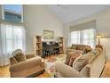 Inviting living room with large windows, hardwood floors, and comfortable seating around a piano at 20530 Parker Vista Cir, Parker, CO 80138