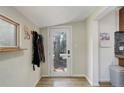 Bright entryway featuring a glass door, coat rack, and wood-look flooring at 6743 Wild Rose Ln, Evergreen, CO 80439