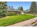 Charming brick home featuring a well-manicured lawn and mature landscaping, a home with great curb appeal at 798 Alkire St, Lakewood, CO 80401