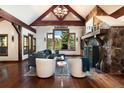 Open living room featuring vaulted ceilings, wood beams, and a stone fireplace at 41 Stillson Placer Ter, Breckenridge, CO 80424