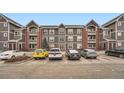 Exterior of a modern apartment building showing neutral siding and parking with partial snow covering on the ground at 14211 E 1St Dr # 308, Aurora, CO 80011