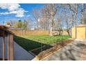 Large grassy backyard with a wooden fence, garden plot and a storage shed at 2060 S Lowell Blvd, Denver, CO 80219