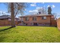 Large, well-maintained backyard featuring a lush lawn, mature trees, and a brick home exterior at 2060 S Lowell Blvd, Denver, CO 80219
