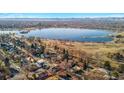 Stunning aerial view of a home near a tranquil lake, showcasing the city skyline and majestic mountains in the distance at 4215 W Byron Pl, Denver, CO 80212