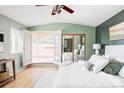 Bright main bedroom with hardwood floors, white linens, and french doors leading to an outdoor deck at 4215 W Byron Pl, Denver, CO 80212
