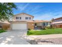 Charming two-story home featuring a lush lawn, brick accents, and an attached two car garage at 7276 W 83Rd Way, Arvada, CO 80003
