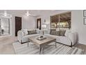 Bright living room with neutral tones, large windows, and stylish furniture at 7720 Kendall St, Arvada, CO 80003