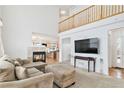 Open living room with a fireplace, high ceilings, a comfortable sofa, and lots of natural light at 24285 E Wagon Trail Ave, Aurora, CO 80016