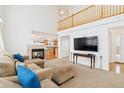 Inviting living room with a cozy fireplace, open floor plan, and a clear view of the modern kitchen at 24285 E Wagon Trail Ave, Aurora, CO 80016