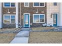Townhome's front entrance with a bright blue door, a concrete path, and fresh landscaping at 374 North Geneva, Aurora, CO 80010
