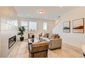 Bright living room with a modern fireplace, neutral furniture, and large windows at 374 North Geneva, Aurora, CO 80010