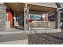 Charming front porch with stone pillars and comfortable seating area at 315 Painted Horse Way, Erie, CO 80516