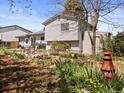 Well-manicured backyard featuring a dining set, a beautiful pond with vibrant flowers and well-maintained lawn at 17900 E Mexico Dr, Aurora, CO 80017