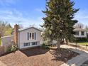Charming home showcasing a lovely, green front yard with mature tree and a paved driveway at 17900 E Mexico Dr, Aurora, CO 80017