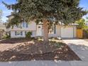 Charming home, featuring an inviting, tree-filled front yard and an attached garage at 17900 E Mexico Dr, Aurora, CO 80017