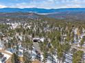 Expansive aerial view showcases the home nestled amongst lush trees and mountain views at 28592 Hummingbird Hill Rd, Conifer, CO 80433