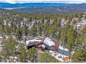 Beautiful aerial view of the home in a wooded area with mountain views at 28592 Hummingbird Hill Rd, Conifer, CO 80433