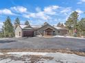 Beautiful exterior view with a large driveway, garage, and inviting entry at 28592 Hummingbird Hill Rd, Conifer, CO 80433