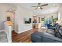 Open-concept living room with hardwood floors, a ceiling fan, and seamless flow into the kitchen and dining area at 1530 Terry St, Longmont, CO 80501