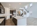 Modern kitchen features stainless steel appliances, dark cabinets, and a large white countertop island at 4588 Thistle Dr, Brighton, CO 80601