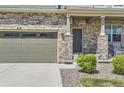 Inviting front entrance with stone detailing, covered porch, and well-manicured landscaping at 417 S Ouray St, Aurora, CO 80017