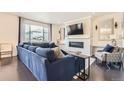 Elegant living room featuring a fireplace, large windows, dark wood floors, and stylish blue sofa at 417 S Ouray St, Aurora, CO 80017