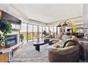 Spacious living room featuring a cozy fireplace, large windows, and comfortable seating with bright, natural light at 1900 E Girard Pl # 907, Englewood, CO 80113