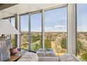 Breathtaking views from the living room with large windows overlooking lush greenery and city skyline at 1900 E Girard Pl # 907, Englewood, CO 80113