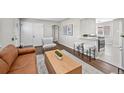 Stylish living room with breakfast bar to kitchen, hardwood floors, contemporary furniture, and modern decor at 500 S Pennsylvania St # 520, Denver, CO 80209