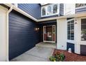 Inviting home entrance featuring stylish navy blue siding, white brick accents, and a charming red door at 9924 Silver Maple Way, Highlands Ranch, CO 80129