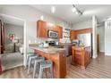 Modern kitchen with wood cabinetry, granite countertops, stainless steel appliances, and an island with bar stool seating at 5401 S Park Terrace Ave # 105A, Greenwood Village, CO 80111