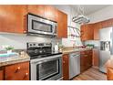 This kitchen features stainless steel appliances, wood cabinets, granite countertops and under cabinet lighting at 5401 S Park Terrace Ave # 105A, Greenwood Village, CO 80111
