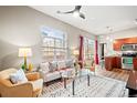 Cozy living room features large windows, stylish furniture, modern ceiling fan, and an open floor plan to the kitchen at 5401 S Park Terrace Ave # 105A, Greenwood Village, CO 80111