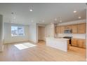 Open-concept living space combines the kitchen and living room with plenty of natural light at 21292 E 63Rd Dr, Aurora, CO 80019