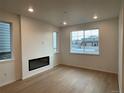 Bright living room featuring a modern fireplace and hardwood floors at 21292 E 63Rd Dr, Aurora, CO 80019