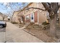 Attractive townhome exterior with brick accents, concrete walkway and a mature tree at 1545 S Ouray Cir # A, Aurora, CO 80017