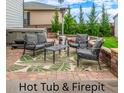 Enjoy outdoor living with a hot tub, fire pit, and comfortable seating area on a brick patio at 12330 Village E Cir, Commerce City, CO 80603