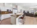 Modern kitchen with white cabinets, granite countertops, and a cozy breakfast bar at 301 Garfield St # 1E, Denver, CO 80206