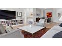Bright living room with a large TV, built-in shelving, and stylish furniture arrangement at 301 Garfield St # 1E, Denver, CO 80206