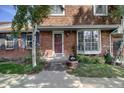 Attractive brick townhome featuring a welcoming entrance, complemented by lovely landscaping at 7396 S Knolls Way, Centennial, CO 80122