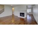 Open living space with hardwood floors, a fireplace, and stairs leading to the upper level at 7396 S Knolls Way, Centennial, CO 80122